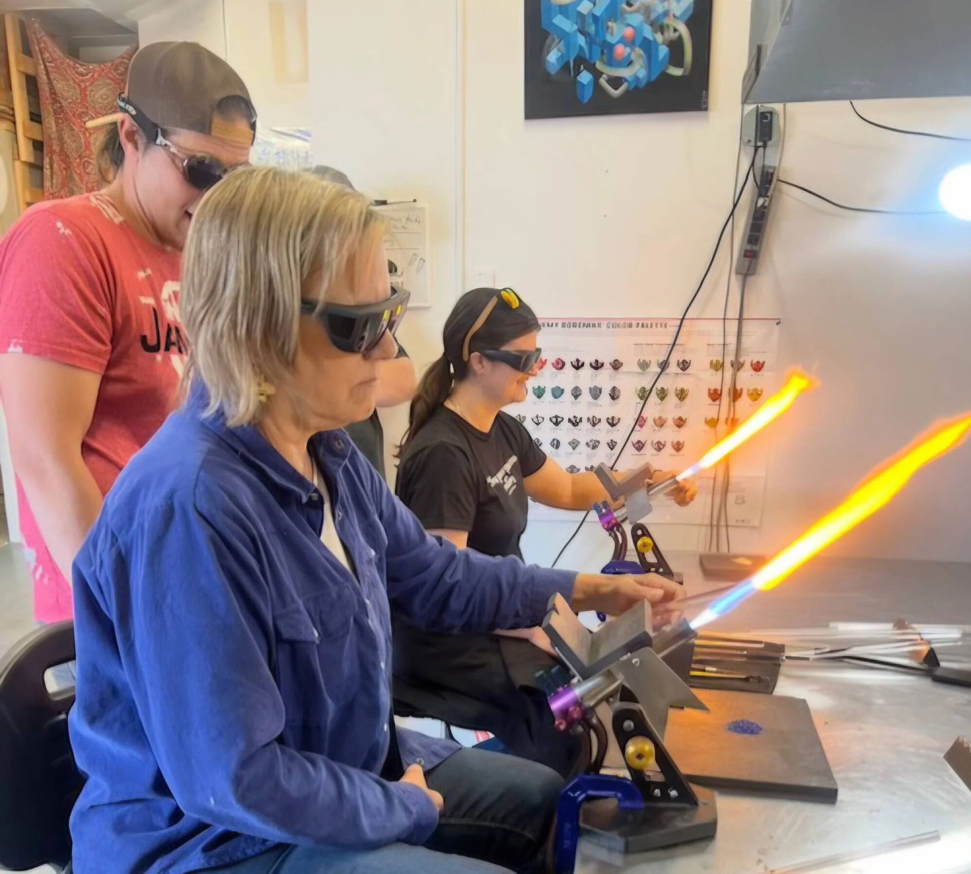 A student working molten glass at the torch