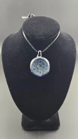 Deep Cell, a hand-blown glass pendant by Jared Omas with a receding honeycomb pattern in rich blue and icy white