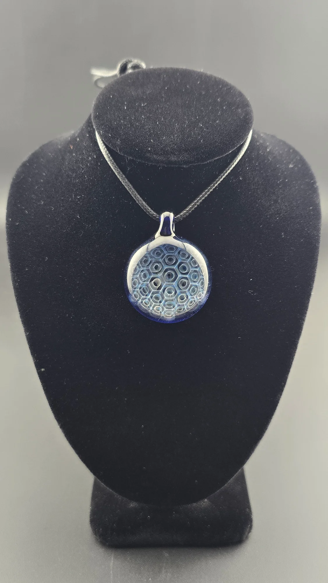Deep Cell, a hand-blown glass pendant by Jared Omas with a receding honeycomb pattern in rich blue and icy white